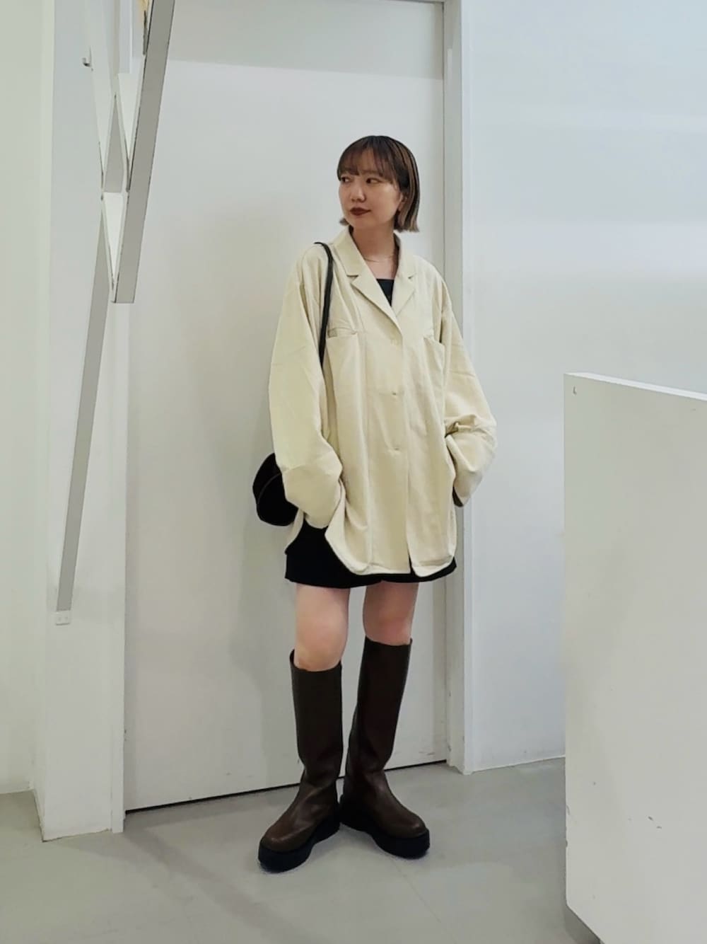 ホワイト系のシャツ/ブラウス、ブラウン系のブーツを着用したレディースの秋コーディネートの1枚目の写真