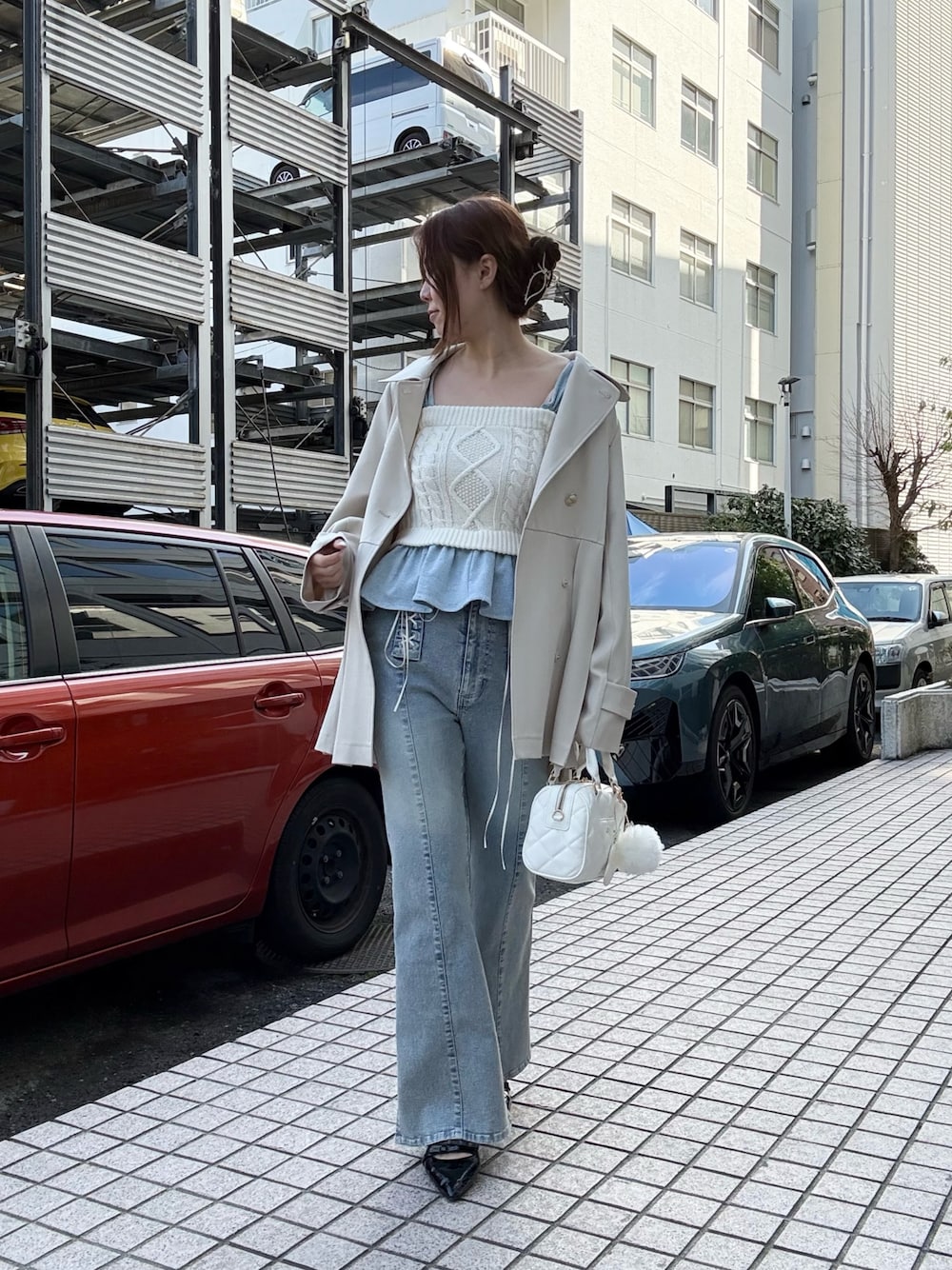 ホワイト系のトレンチコート、ホワイト系のその他トップス、ブルー系のデニムパンツを着用したレディースの冬コーディネートの1枚目の写真