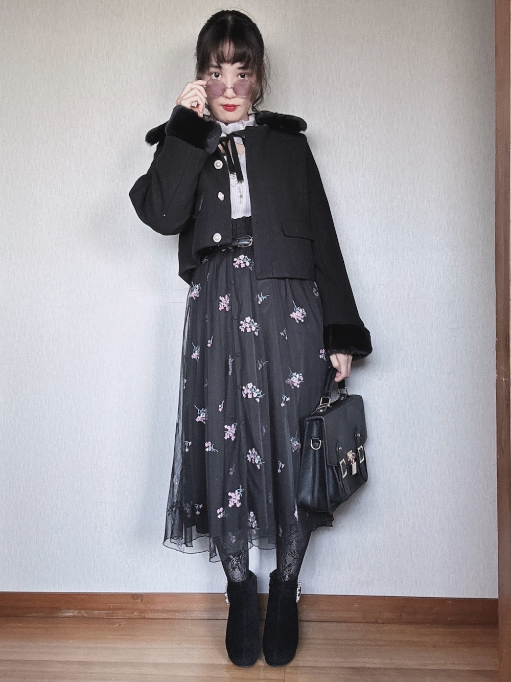 ブラック系のブーツ、ブラック系のスカート、ブラック系のボストンバッグを着用したレディースの秋コーディネートの1枚目の写真