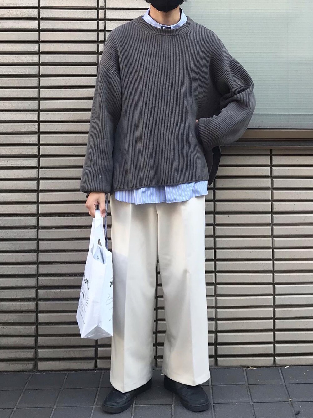 グレー系のニット/セーター、ブルー系のシャツ/ブラウス、ホワイト系のスラックスを着用したメンズの春コーディネートの1枚目の写真