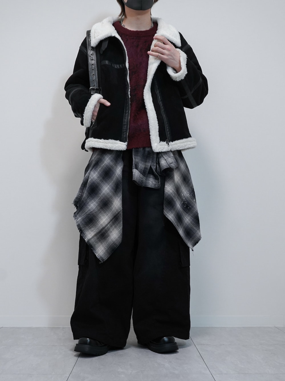 ホワイト系のムートンコート、レッド系のニット/セーター、ブラック系のカーゴパンツを着用したメンズの秋コーディネートの1枚目の写真