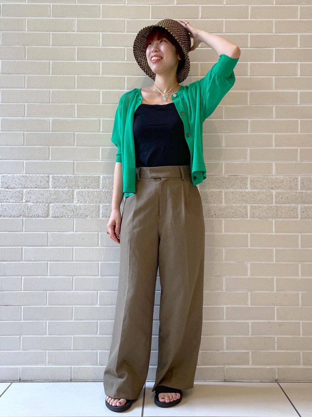 ブラウン系のその他パンツ、グリーン系のカーディガン/ボレロ、ブラック系のハットを着用したレディースの春コーディネートの1枚目の写真