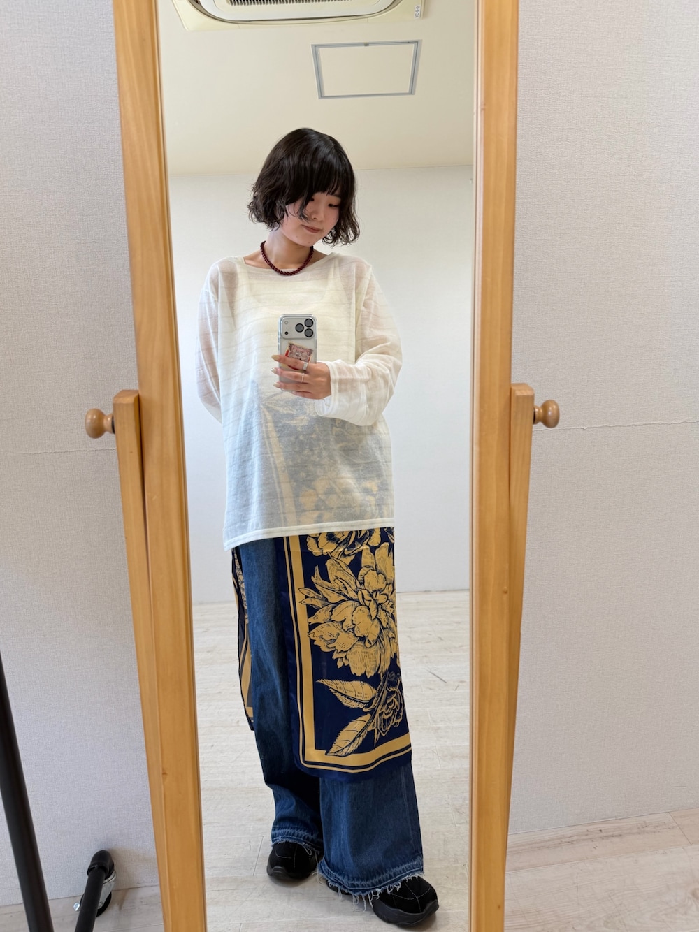 ホワイト系のニット/セーター、ブルー系のデニムパンツ、ブラック系のスニーカーを着用したレディースの秋コーディネートの1枚目の写真