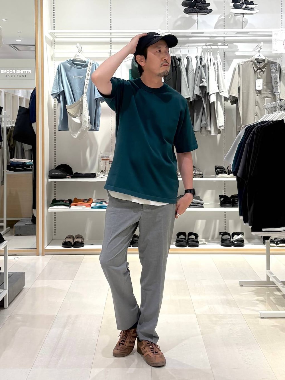 グレー系のスラックス、グリーン系のTシャツ/カットソーを着用したメンズの夏コーディネートの1枚目の写真