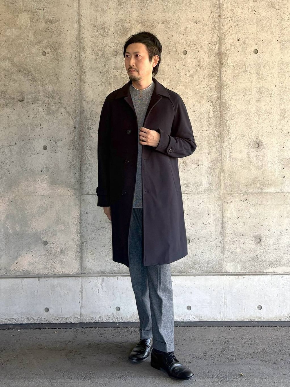 ブルー系のステンカラーコート、グレー系のスラックス、グレー系のニット/セーターを着用したメンズの秋コーディネートの1枚目の写真