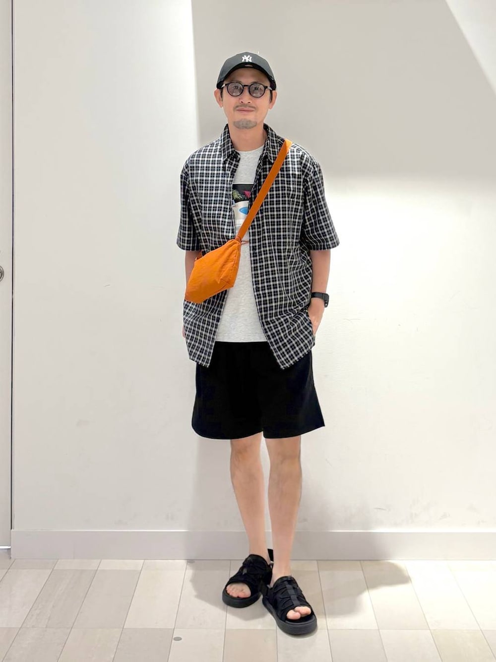 ブラック系のシャツ/ブラウス、ブラック系のその他パンツ、オレンジ系のショルダーバッグを着用したメンズの夏コーディネートの1枚目の写真