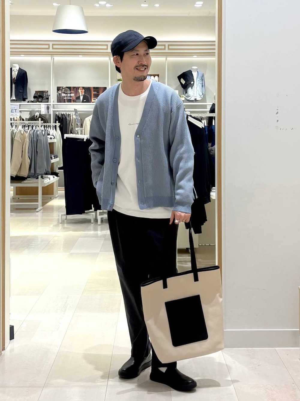 グレー系のその他シューズ、グレー系のその他パンツ、ホワイト系のトートバッグを着用したメンズの春コーディネートの1枚目の写真