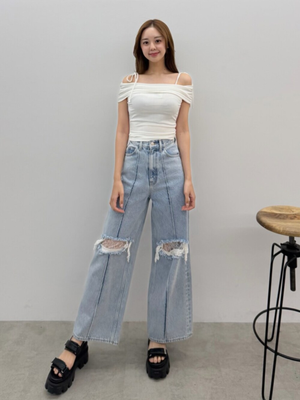 ブルー系のデニムパンツ、ホワイト系のTシャツ/カットソー、ブラック系のサンダルを着用したレディースの春コーディネートの1枚目の写真
