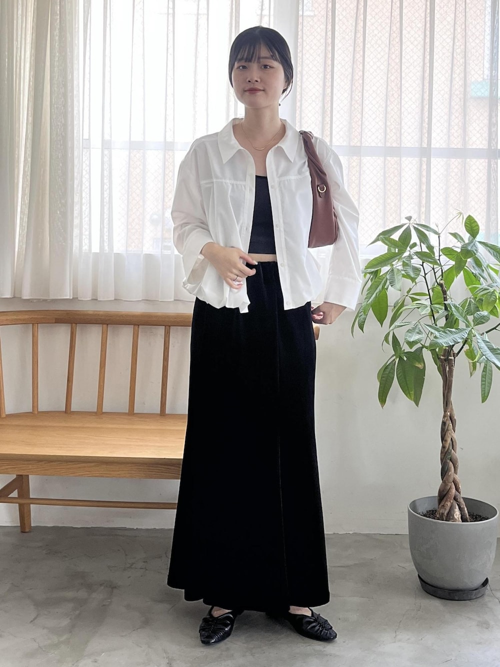 ブラック系のパンプス、ブラウン系のハンドバッグ、ホワイト系のシャツ/ブラウスを着用したレディースの秋コーディネートの1枚目の写真