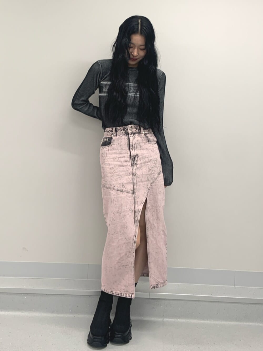 ブラック系のブーツ、ブラック系のニット/セーター、ピンク系のデニムスカートを着用したレディースの春コーディネートの1枚目の写真