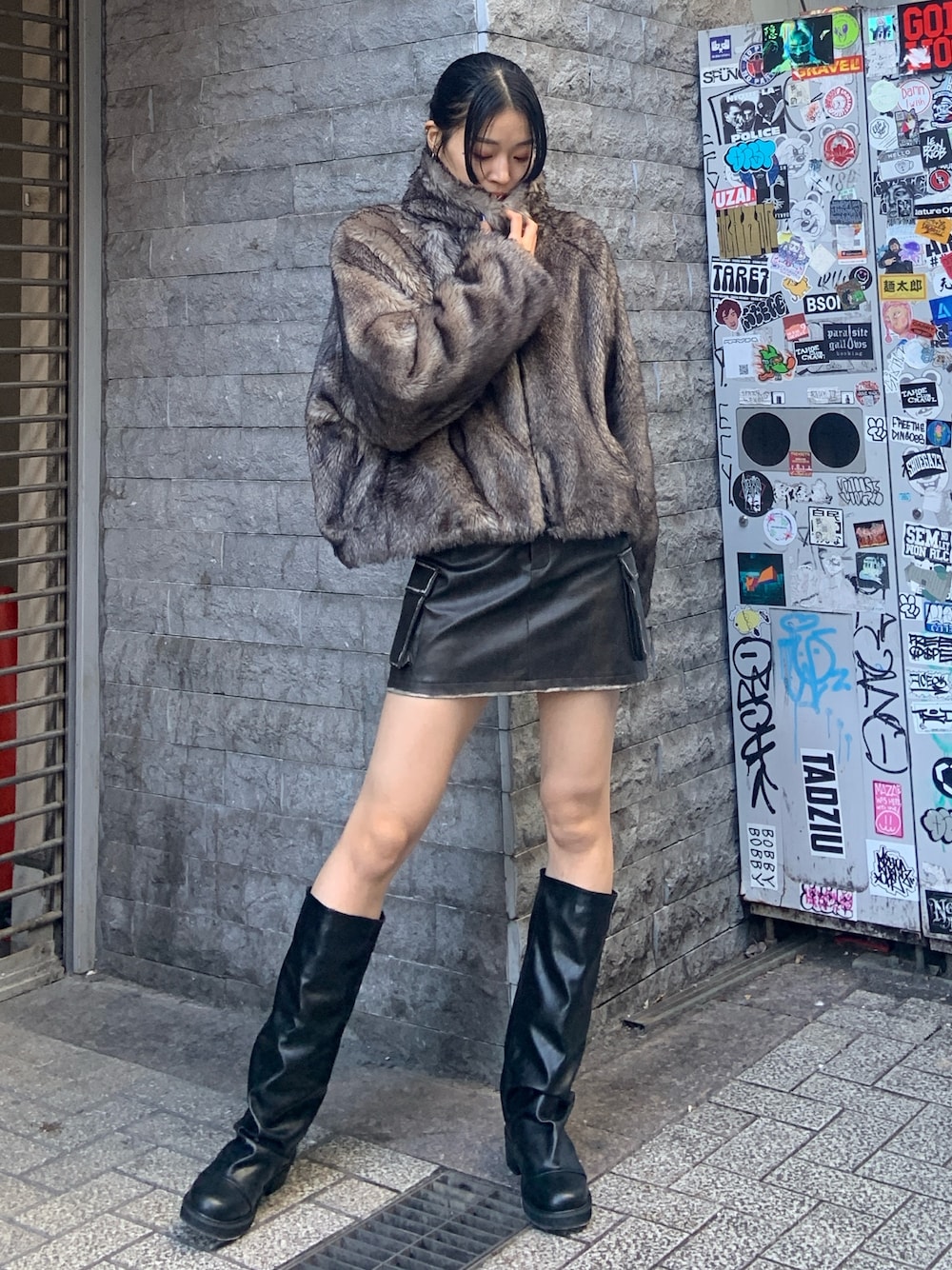 グレー系のブルゾン、ブラウン系のスカート、ブラック系のブーツを着用したレディースの冬コーディネートの1枚目の写真