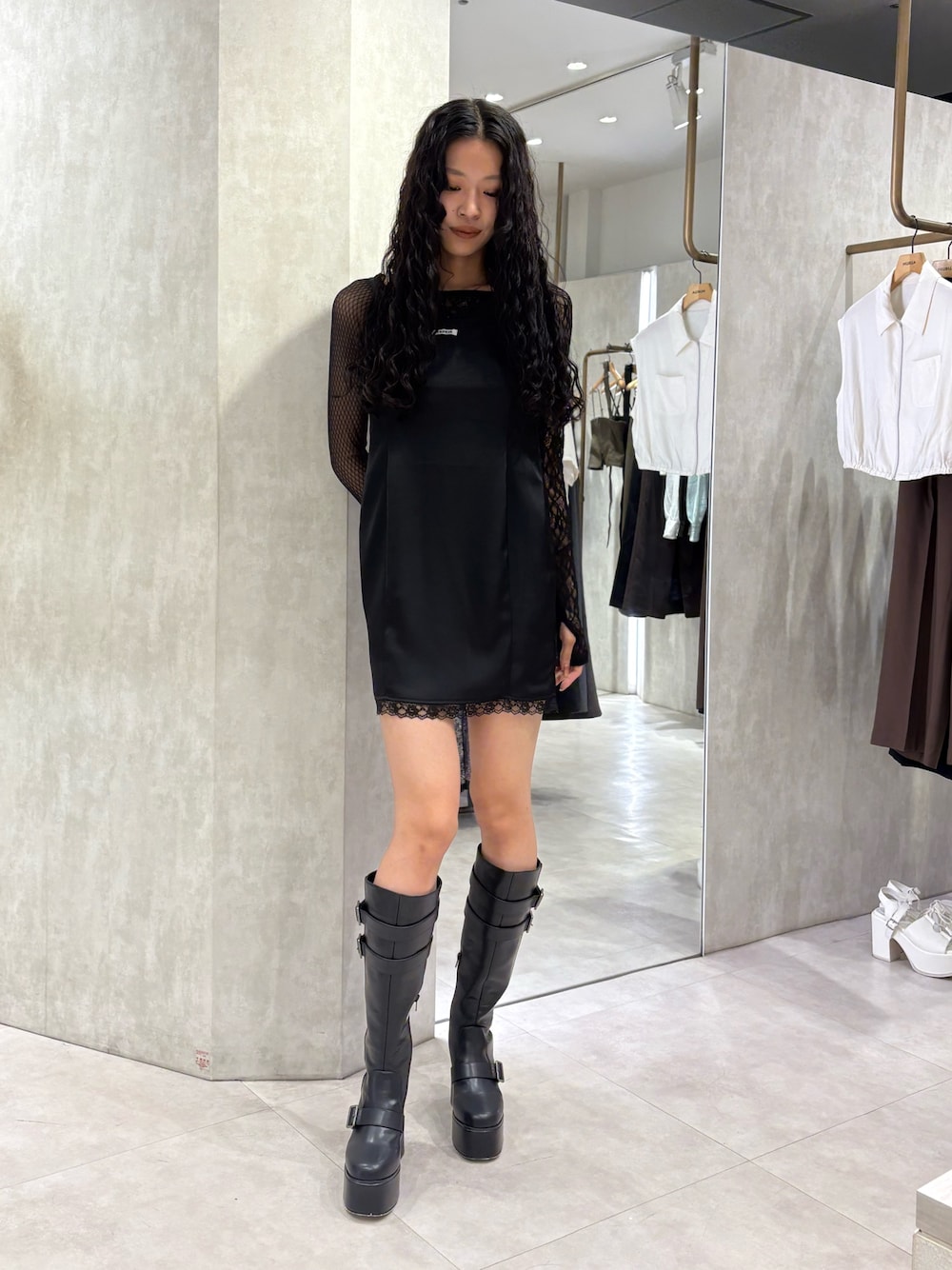 ブラック系のワンピース、ブラック系のTシャツ/カットソー、ブラック系のブーツを着用したレディースの秋コーディネートの1枚目の写真