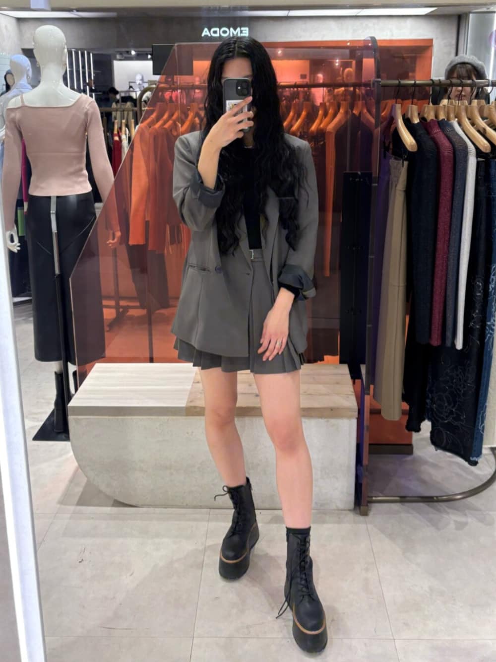 ブラック系のブーツ、グレー系のテーラードジャケット、グレー系のスカートを着用したレディースの冬コーディネートの1枚目の写真