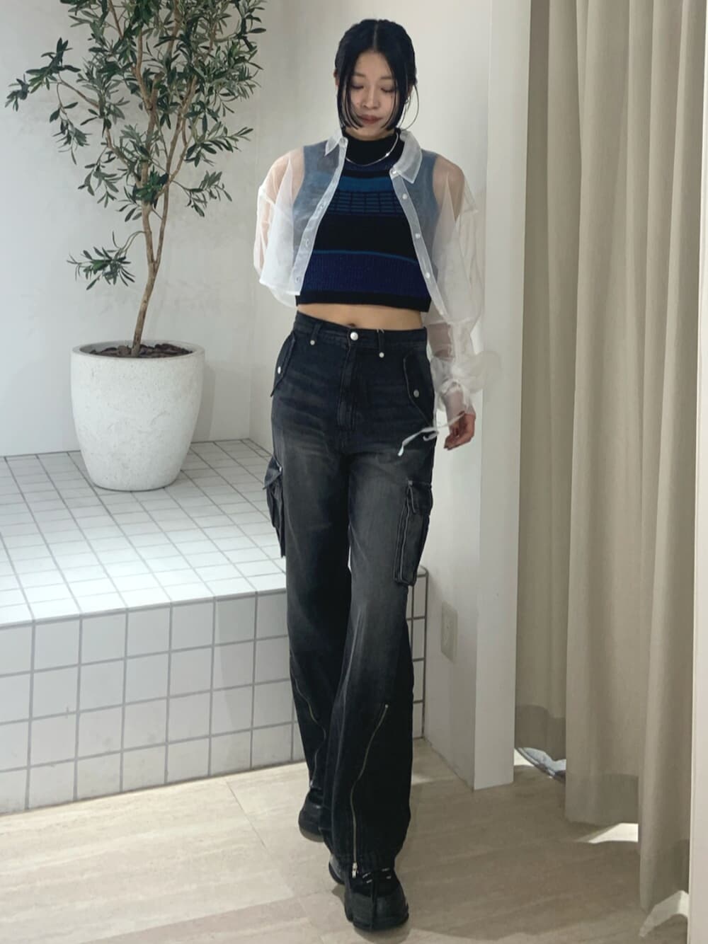 ブラック系のデニムパンツ、ブラック系のスニーカー、ホワイト系のシャツ/ブラウスを着用したレディースの春コーディネートの1枚目の写真