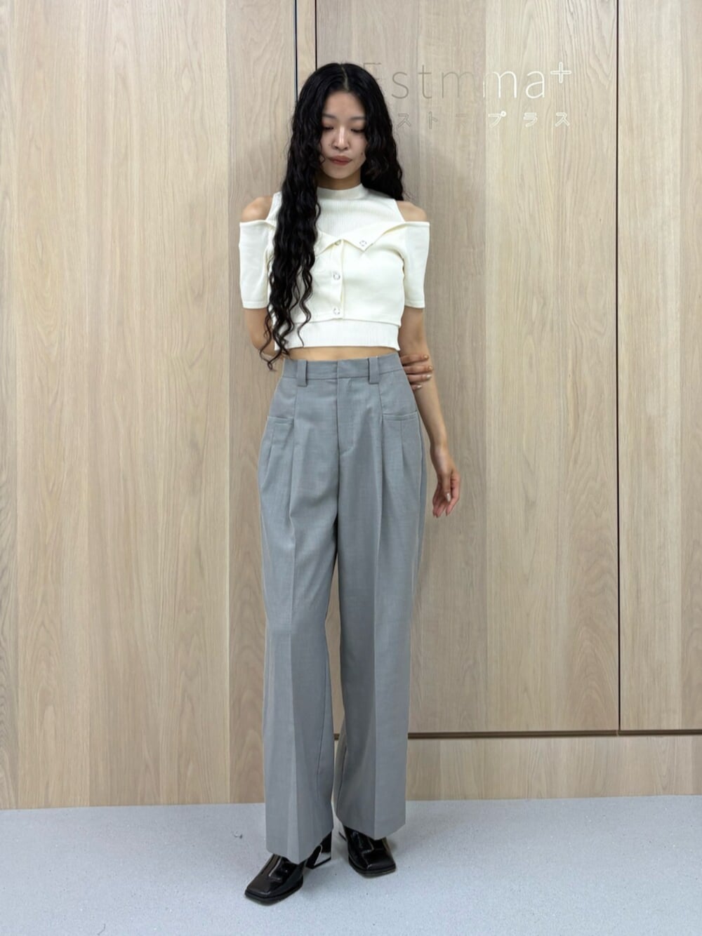 ブラック系のパンプス、グレー系のスラックス、ホワイト系のニット/セーターを着用したレディースの夏コーディネートの1枚目の写真