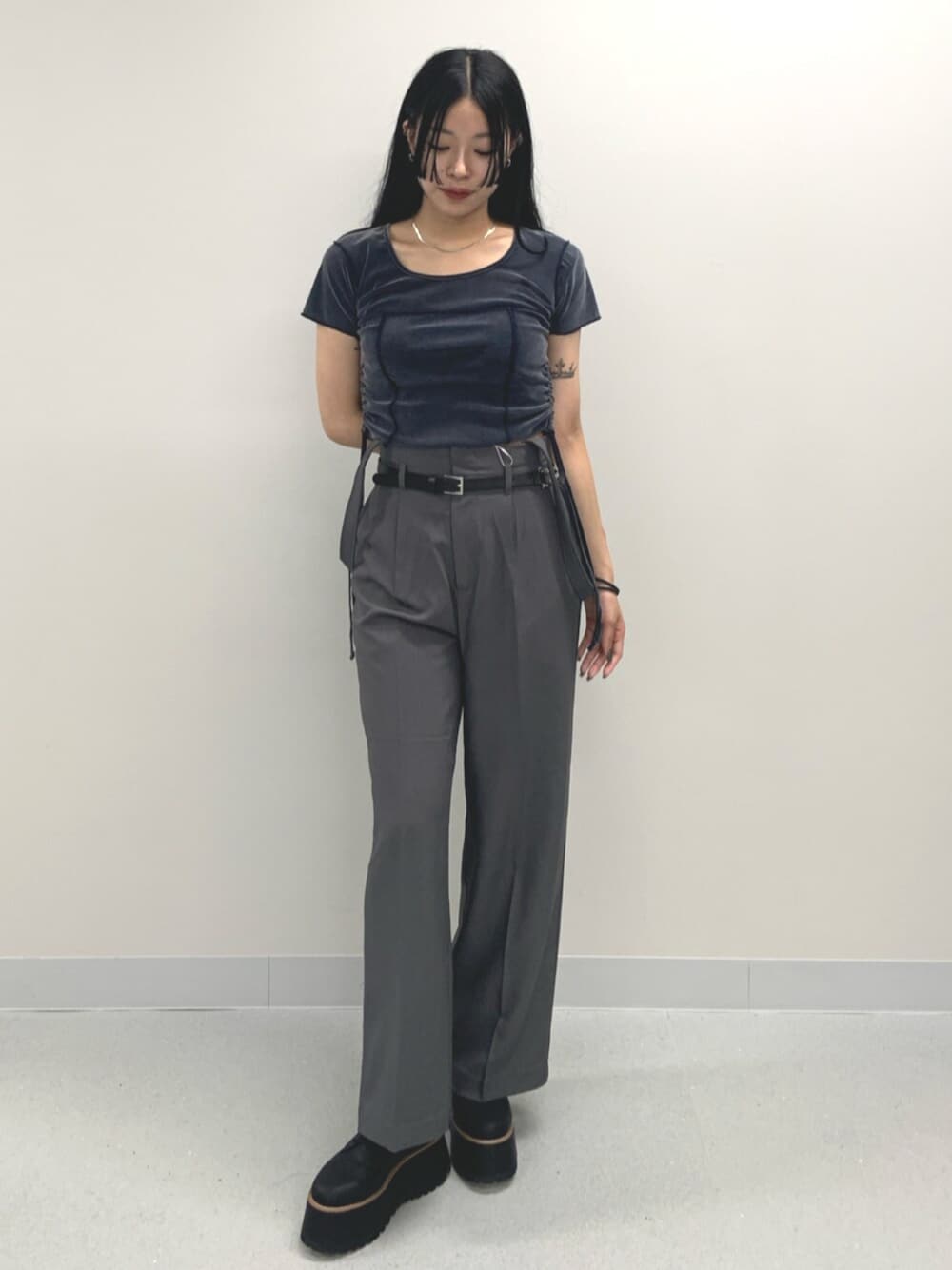 ブルー系のTシャツ/カットソー、ブラック系のブーツ、グレー系のスラックスを着用したレディースの夏コーディネートの1枚目の写真