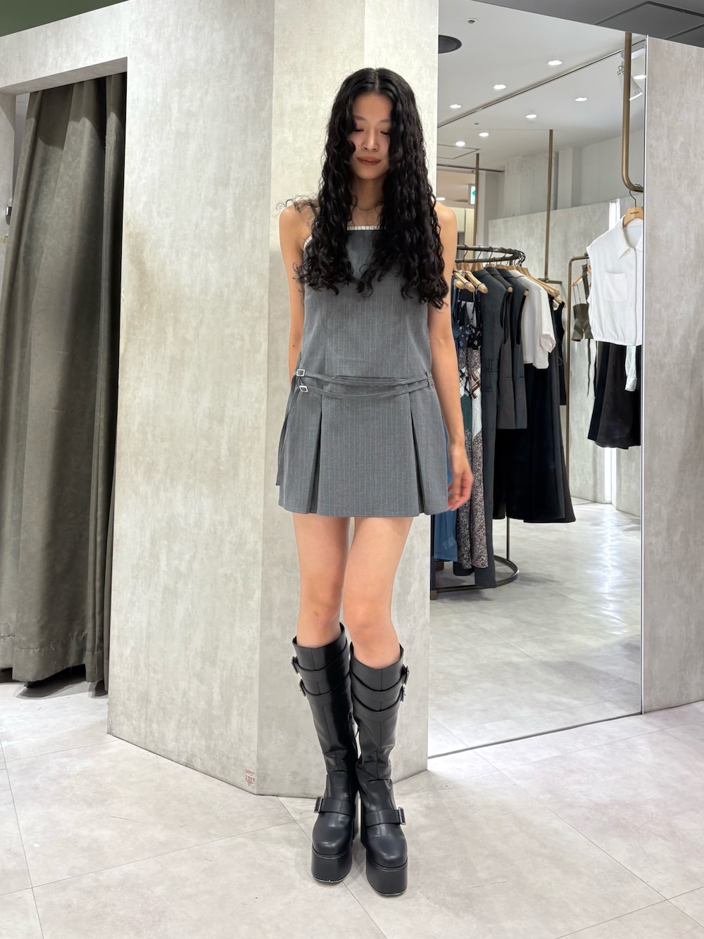 グレー系のワンピース、ブラック系のブーツを着用したレディースの秋コーディネートの1枚目の写真