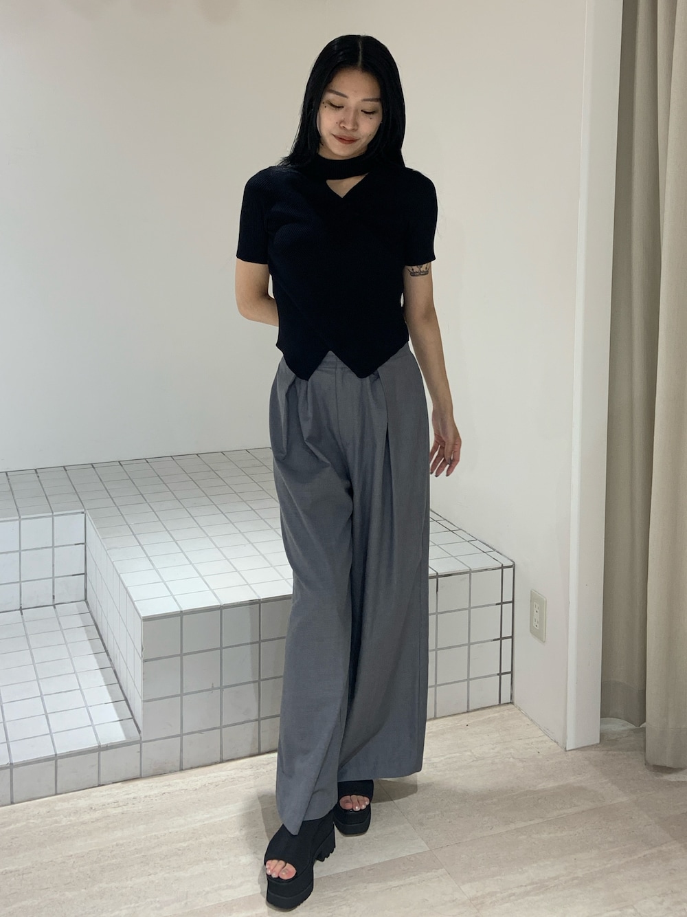 ブラック系のニット/セーター、グレー系のその他パンツ、ブラック系のサンダルを着用したレディースの夏コーディネートの1枚目の写真