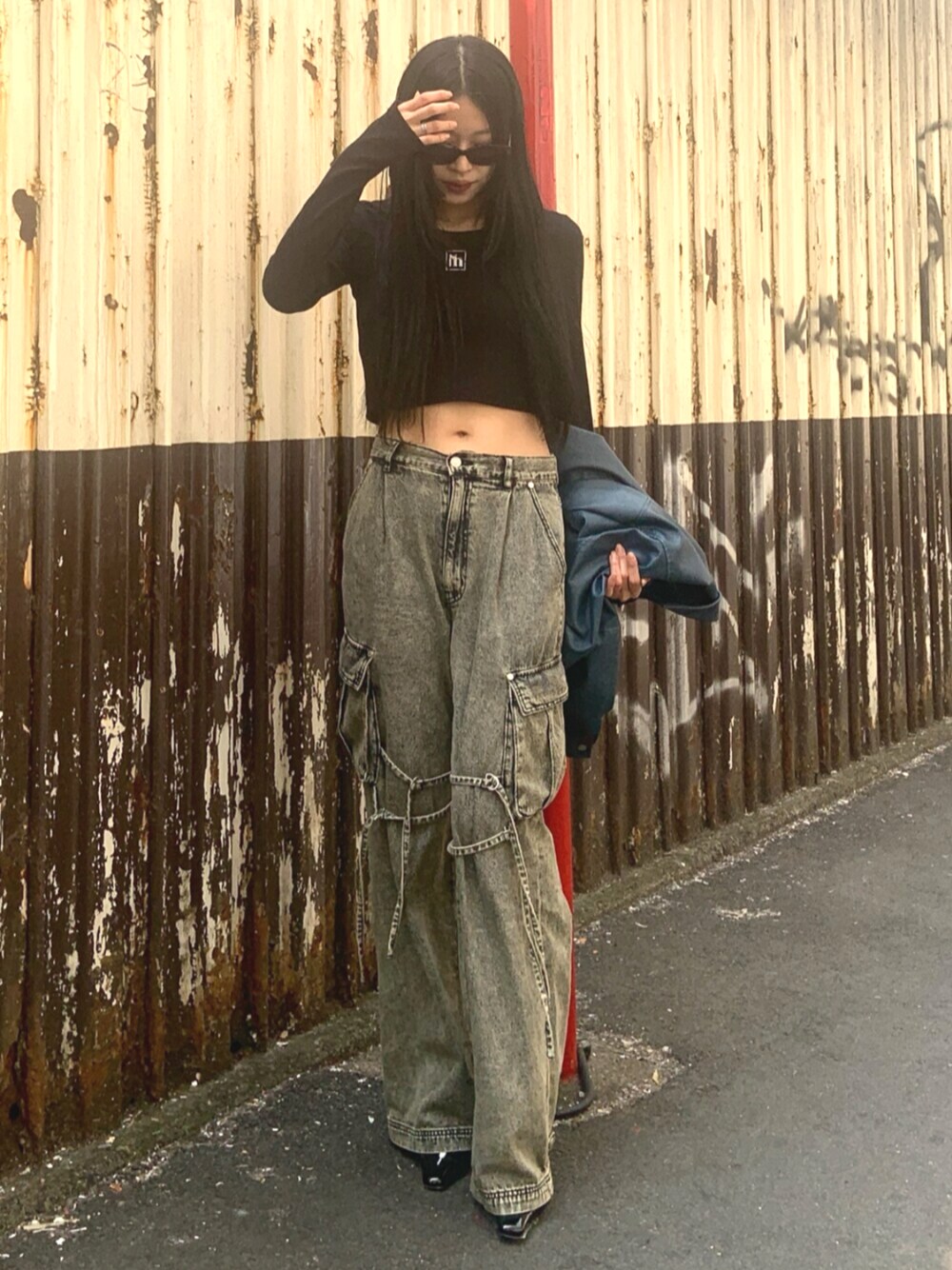 ブラック系のサンダル、ブラック系のTシャツ/カットソー、ブラック系のデニムパンツを着用したレディースの春コーディネートの1枚目の写真