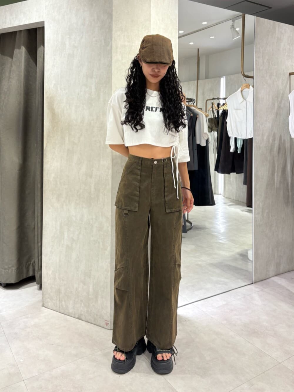 ブラック系のサンダル、ホワイト系のTシャツ/カットソー、ブラウン系のカーゴパンツを着用したレディースの秋コーディネートの1枚目の写真