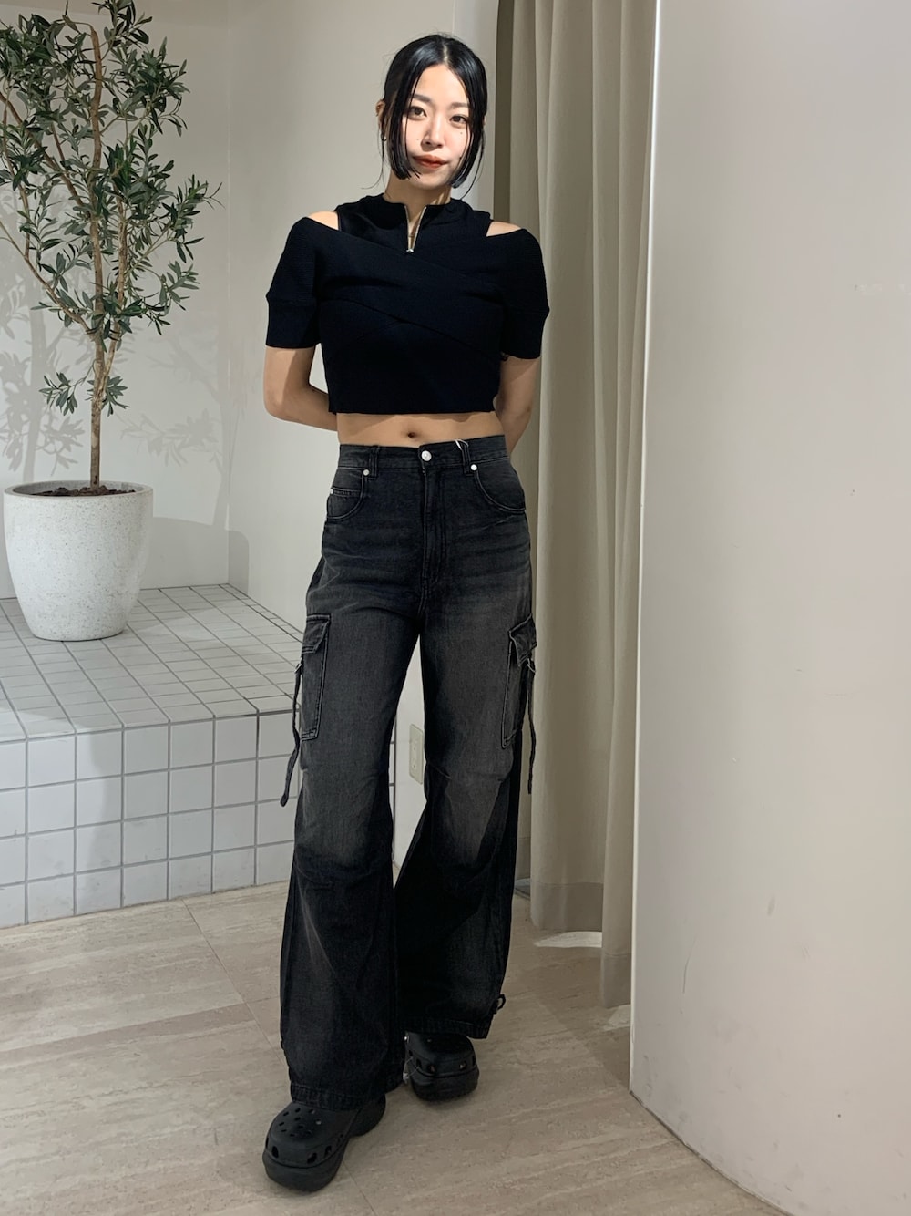 ブラック系のニット/セーター、ブラック系のデニムパンツ、ブラック系のサンダルを着用したレディースの夏コーディネートの1枚目の写真