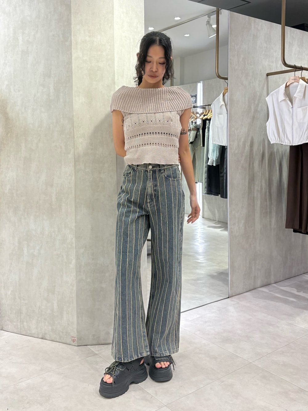 ベージュ系のニット/セーター、ブルー系のデニムパンツ、ブラック系のサンダルを着用したレディースの夏コーディネートの1枚目の写真