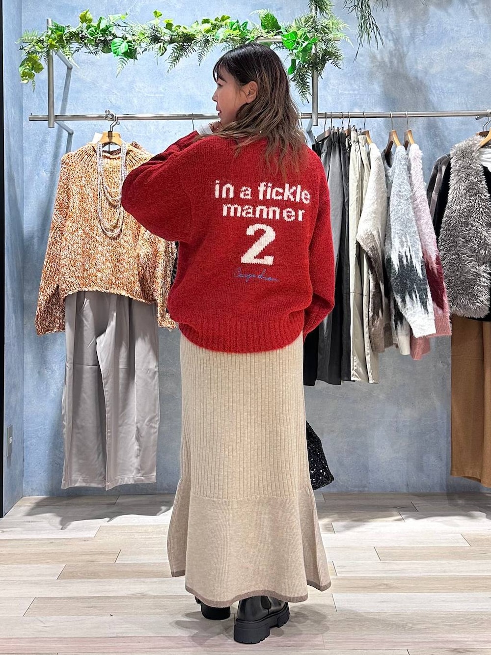 ホワイト系のTシャツ/カットソー、ブラウン系のスカート、レッド系のニット/セーターを着用したレディースの秋コーディネートの1枚目の写真