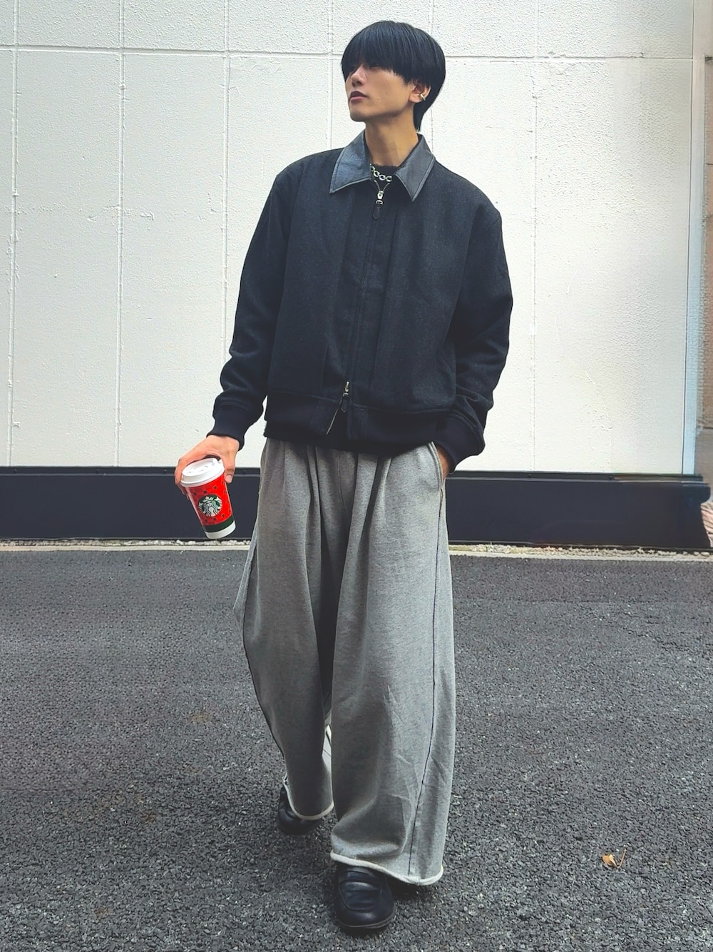 グレー系のブルゾン、グレー系のスウェットパンツ、シルバー系のネックレスを着用したメンズの秋コーディネートの1枚目の写真