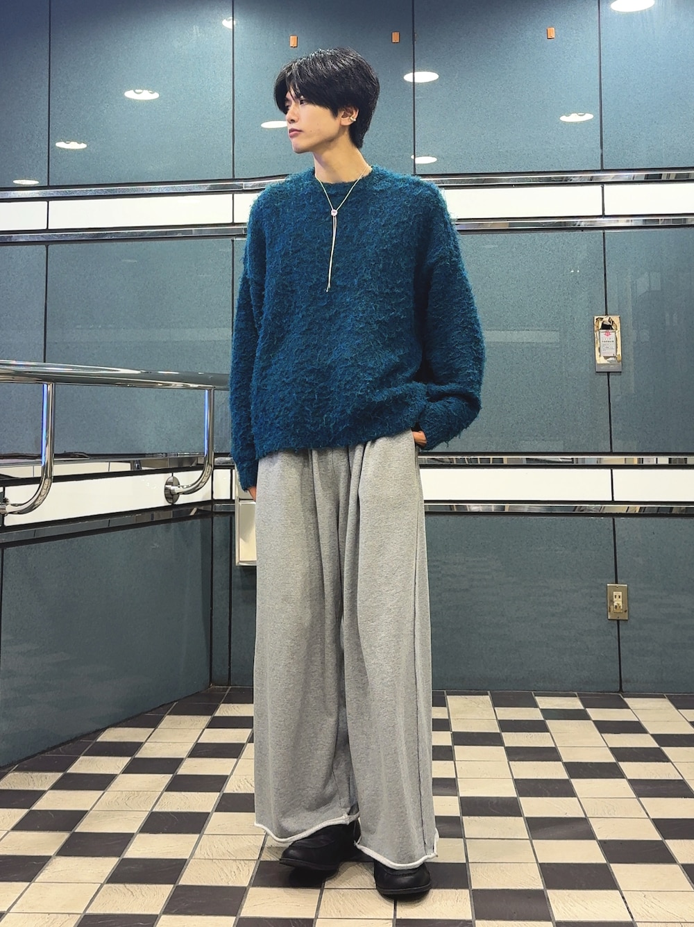 ブルー系のニット/セーター、グレー系のスウェットパンツ、シルバー系のイヤーカフを着用したメンズの秋コーディネートの1枚目の写真