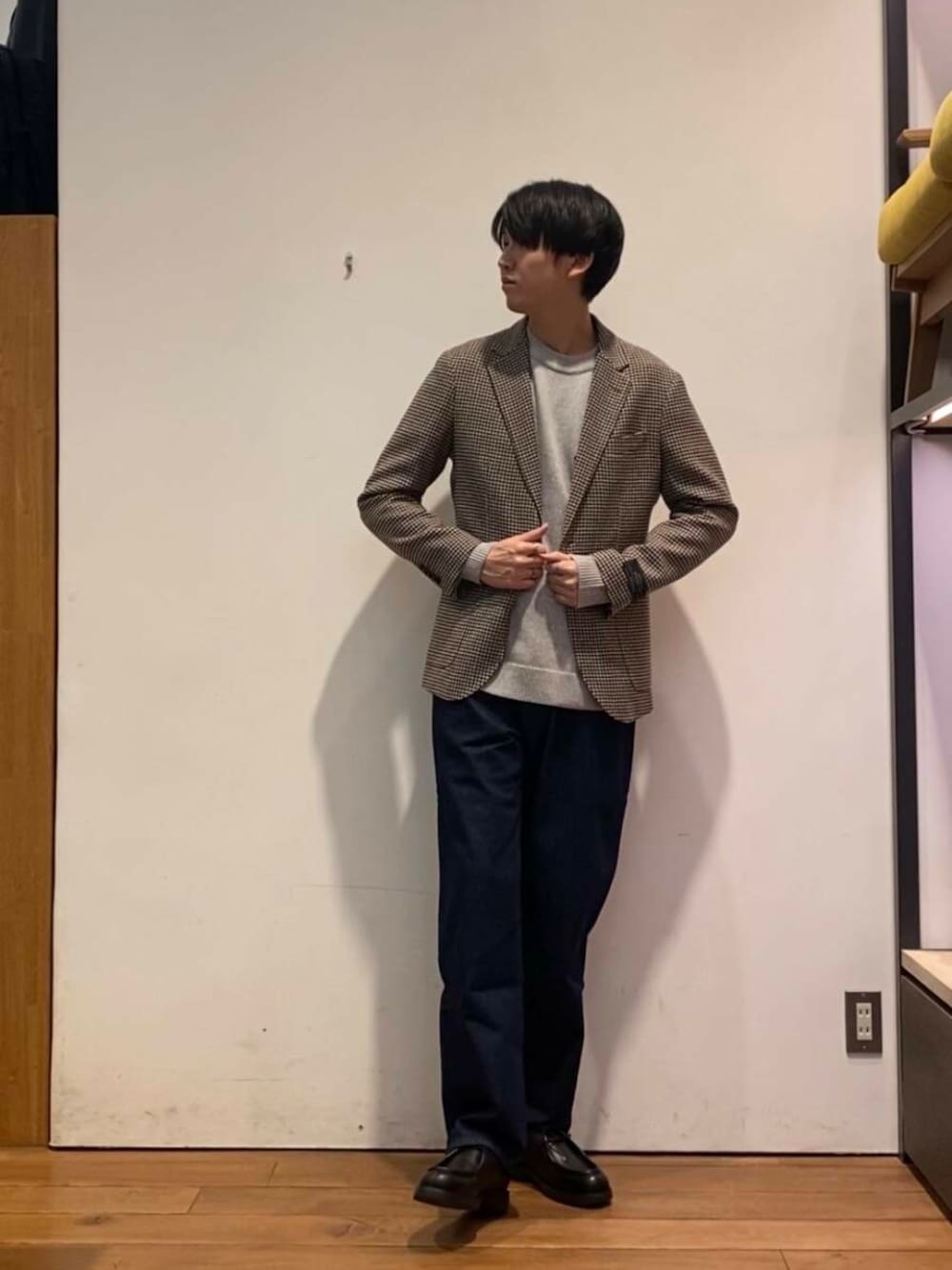 ブルー系のデニムパンツ、グレー系のニット/セーター、ブラウン系のその他アウターを着用したメンズの冬コーディネートの1枚目の写真