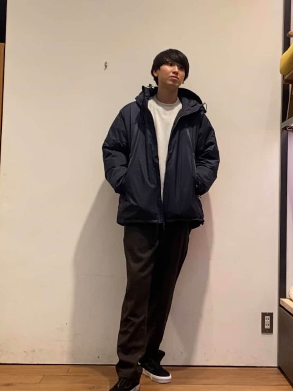 ブルー系のダウンジャケット/コート、ホワイト系のTシャツ/カットソー、ブラウン系のその他パンツを着用したメンズの冬コーディネートの1枚目の写真