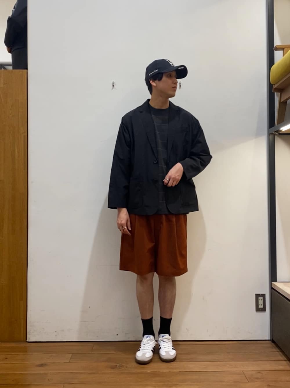 ブラック系のその他アウター、ブラウン系のTシャツ/カットソー、オレンジ系のその他パンツを着用したメンズの春コーディネートの1枚目の写真