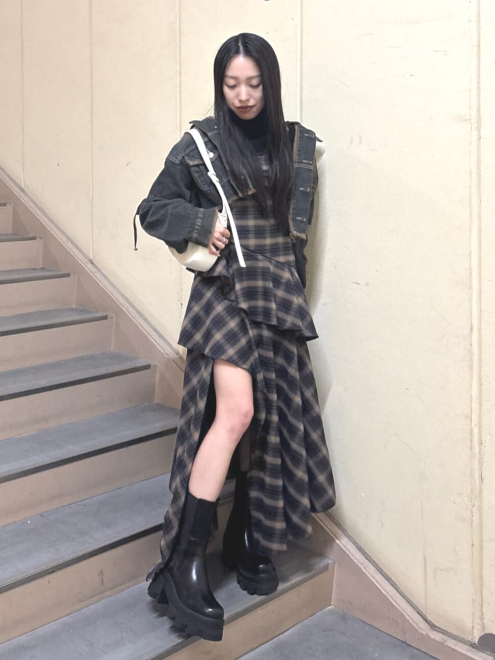 ブラック系のブーツ、ブルー系のデニムジャケット、ブルー系のワンピースを着用したレディースの春コーディネートの1枚目の写真