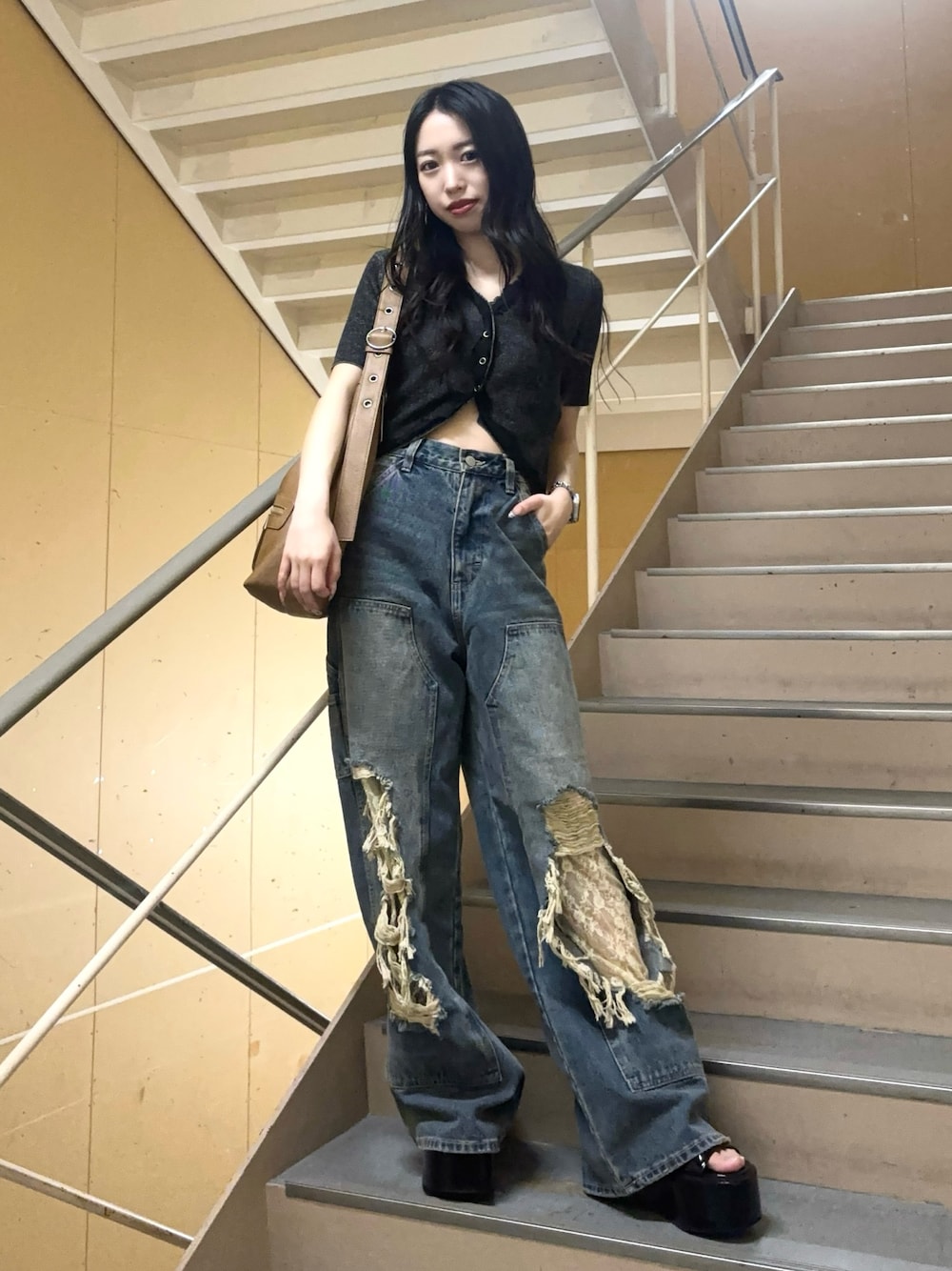 ブルー系のデニムパンツ、ブラック系のニット/セーター、ブラック系のサンダルを着用したレディースの夏コーディネートの1枚目の写真