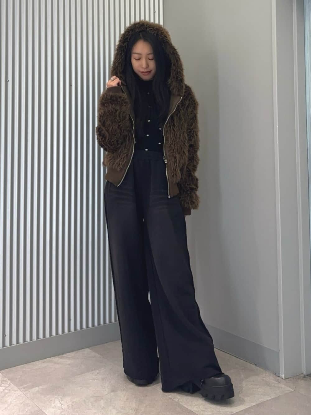 ブラウン系のブルゾン、その他のニット/セーター、ブラック系のスウェットパンツを着用したレディースの冬コーディネートの1枚目の写真