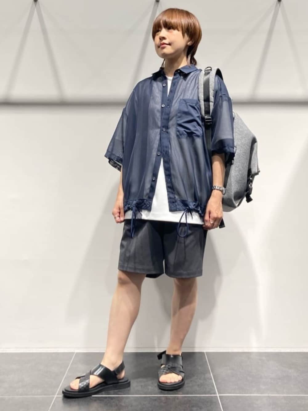 グレー系のボディバッグ/ウエストポーチ、ホワイト系のTシャツ/カットソー、ブラック系のサンダルを着用したレディースの春コーディネートの1枚目の写真