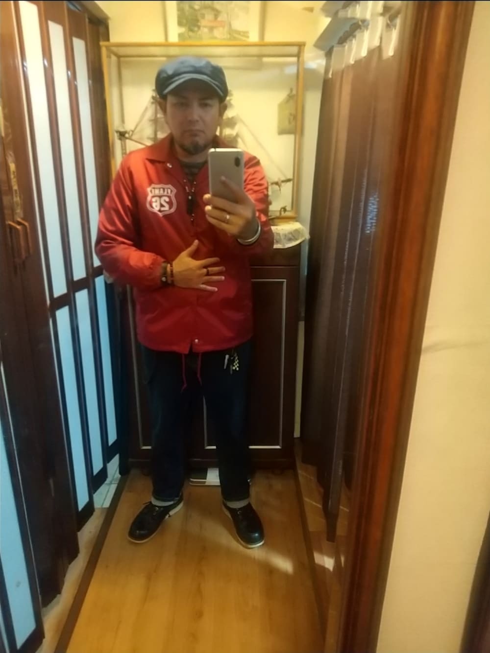 ブラック系のブーツ、ブルー系のデニムパンツ、レッド系のナイロンジャケットを着用したメンズの秋コーディネートの1枚目の写真