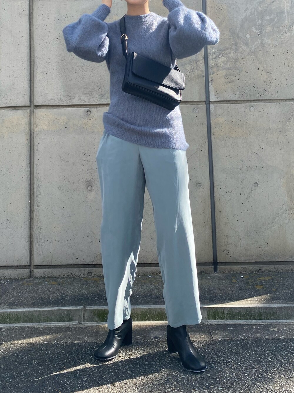 ブラック系のショルダーバッグ、ブラック系のブーツを着用したレディースの冬コーディネートの1枚目の写真