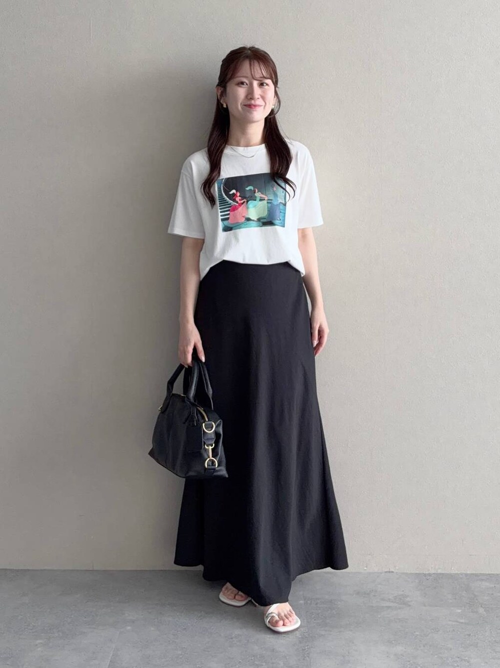 ブラック系のボストンバッグ、ブラック系のスカート、ホワイト系のTシャツ/カットソーを着用したレディースの夏コーディネートの1枚目の写真
