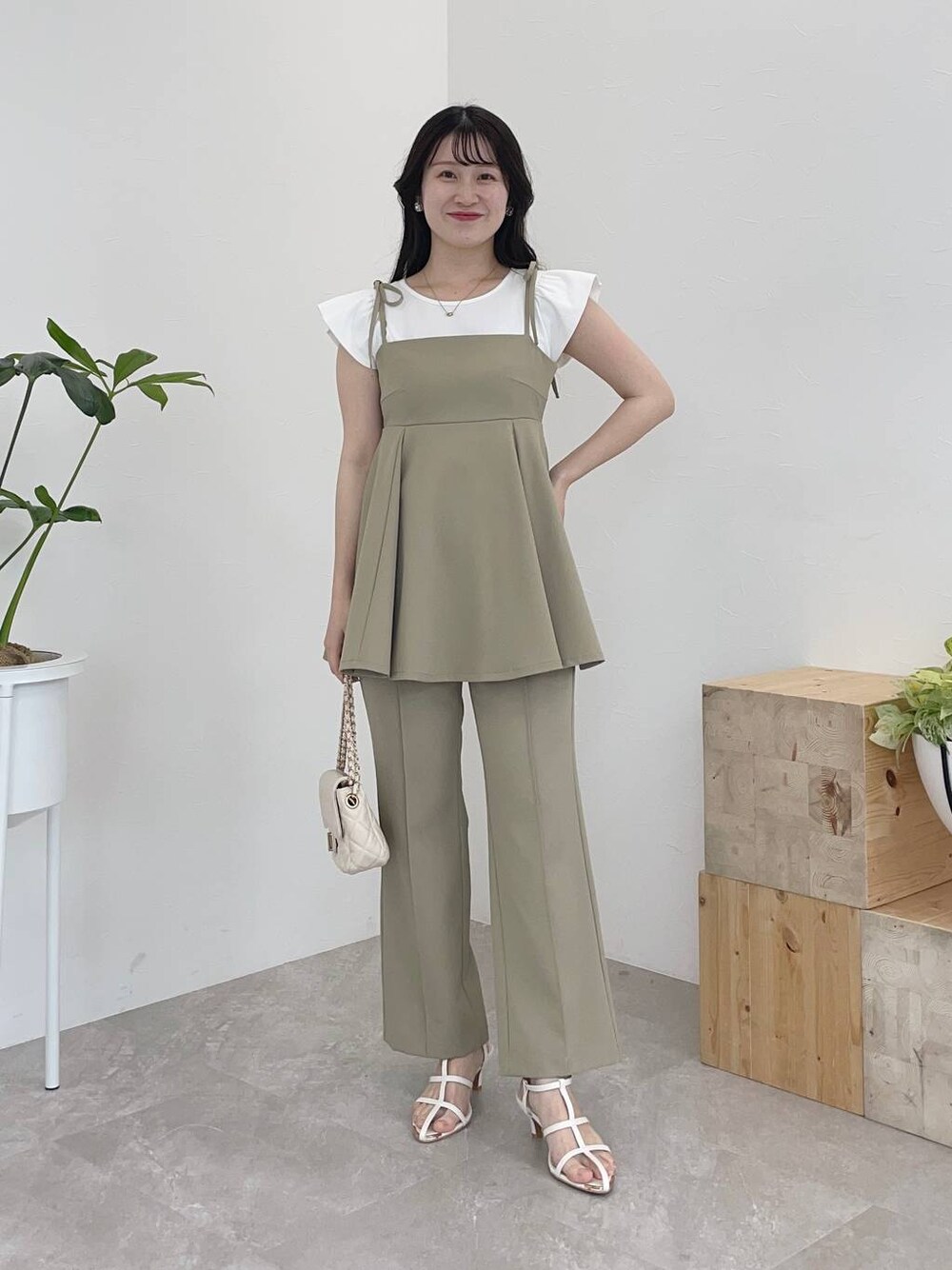 グリーン系のキャミソール、グリーン系のその他パンツ、ホワイト系のショルダーバッグを着用したレディースの春コーディネートの1枚目の写真