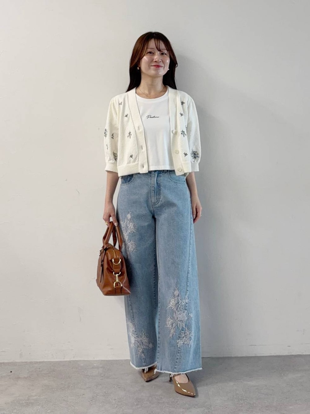 ホワイト系のTシャツ/カットソー、ホワイト系のカーディガン/ボレロ、ブルー系のデニムパンツを着用したレディースの秋コーディネートの1枚目の写真