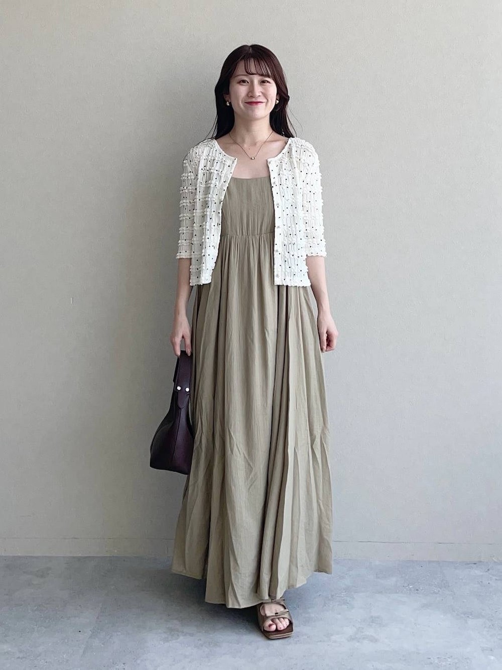 ブラウン系のサンダル、ブラウン系のショルダーバッグ、ベージュ系のワンピースを着用したレディースの夏コーディネートの1枚目の写真