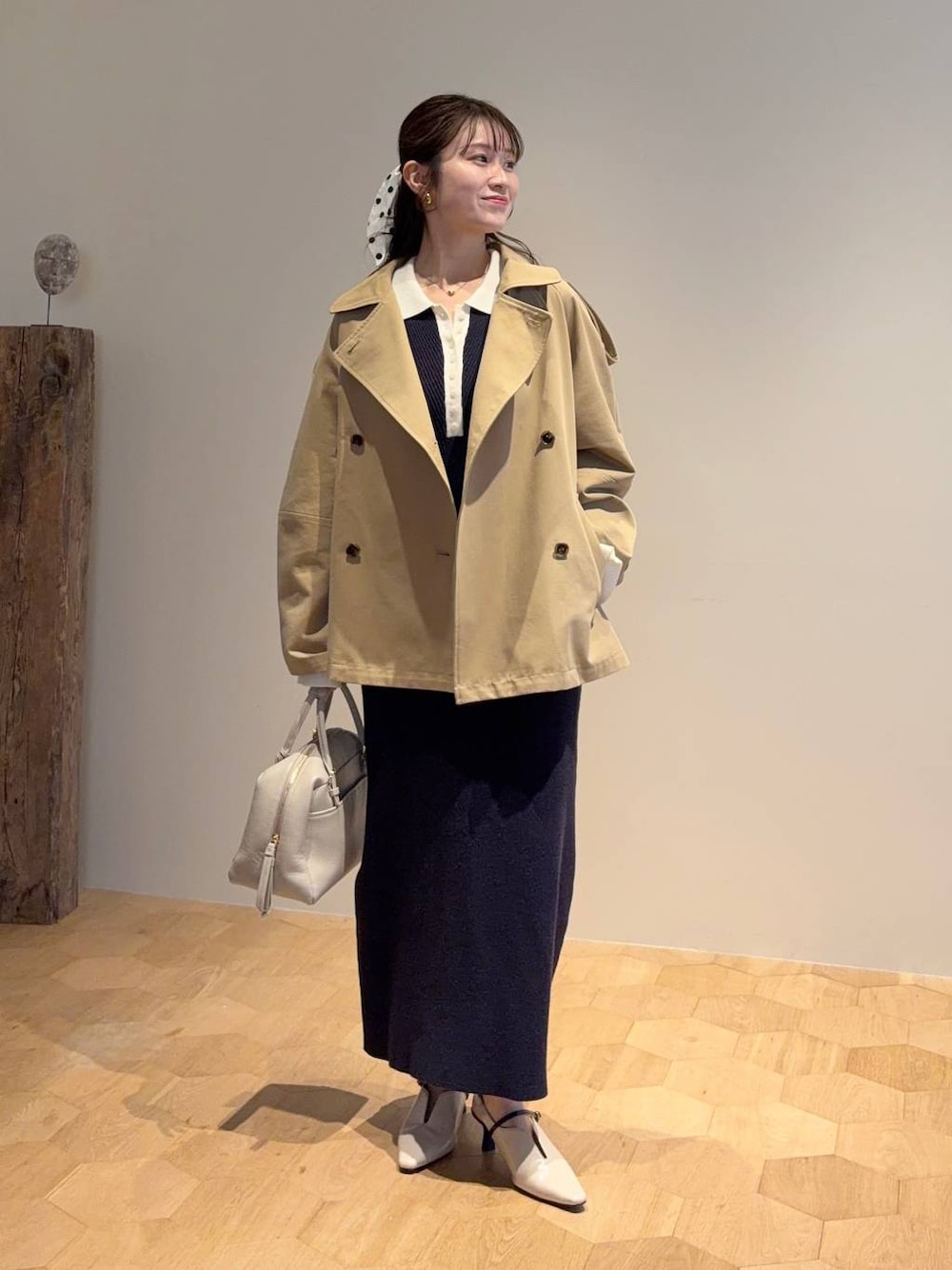 ベージュ系のハンドバッグ、ブルー系のワンピース、ホワイト系のサンダルを着用したレディースの冬コーディネートの1枚目の写真