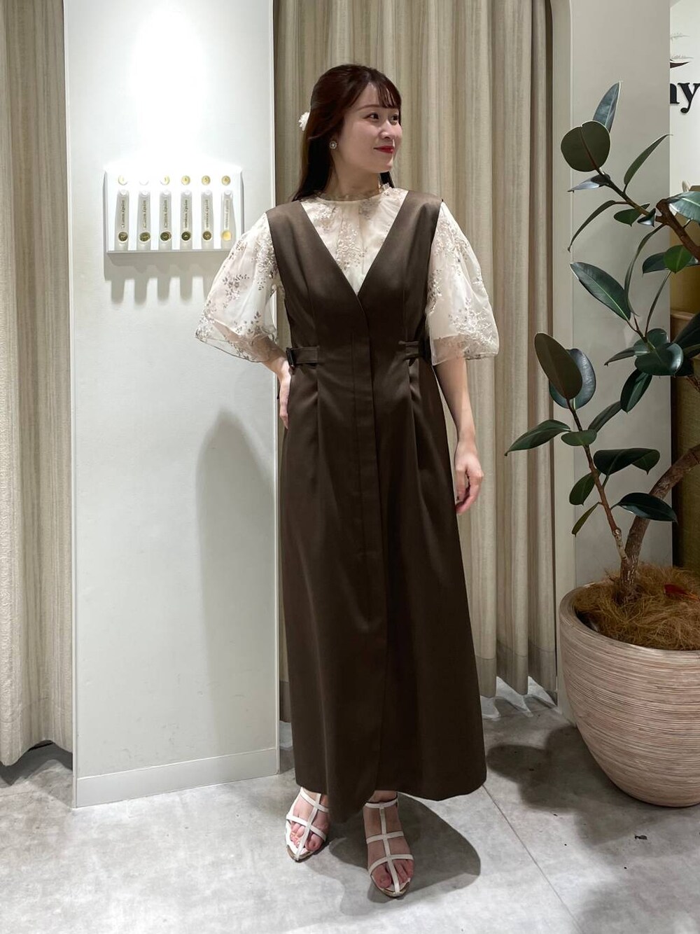 ホワイト系のシャツ/ブラウス、ホワイト系のサンダル、ブラウン系のジャンパースカートを着用したレディースの夏コーディネートの1枚目の写真