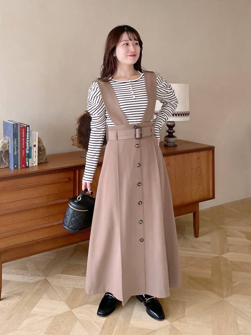 ブラック系のローファー、ブラック系のショルダーバッグ、ホワイト系のTシャツ/カットソーを着用したレディースの冬コーディネートの1枚目の写真