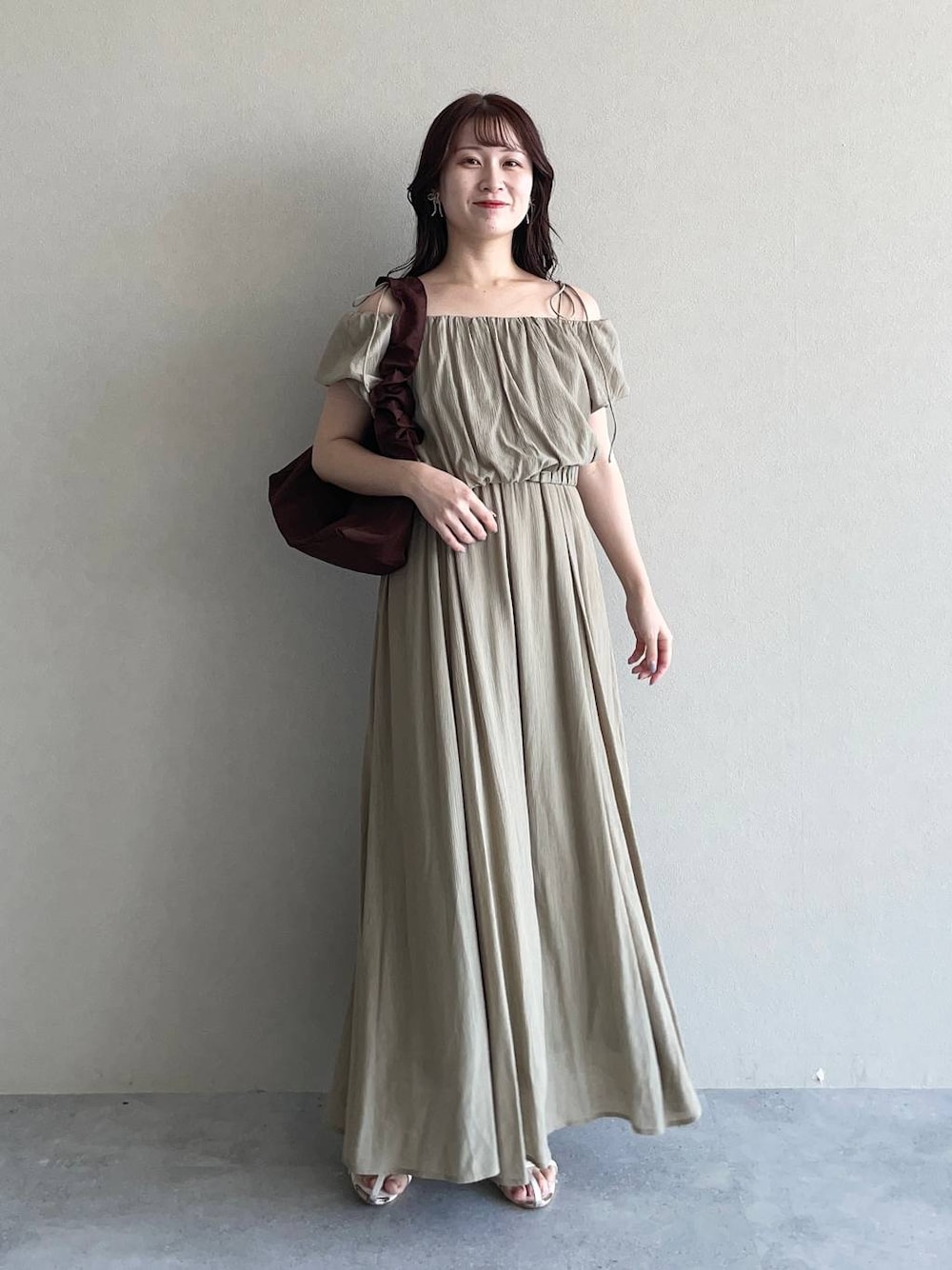 グリーン系のワンピース、ブラウン系のショルダーバッグ、ホワイト系のサンダルを着用したレディースの夏コーディネートの1枚目の写真