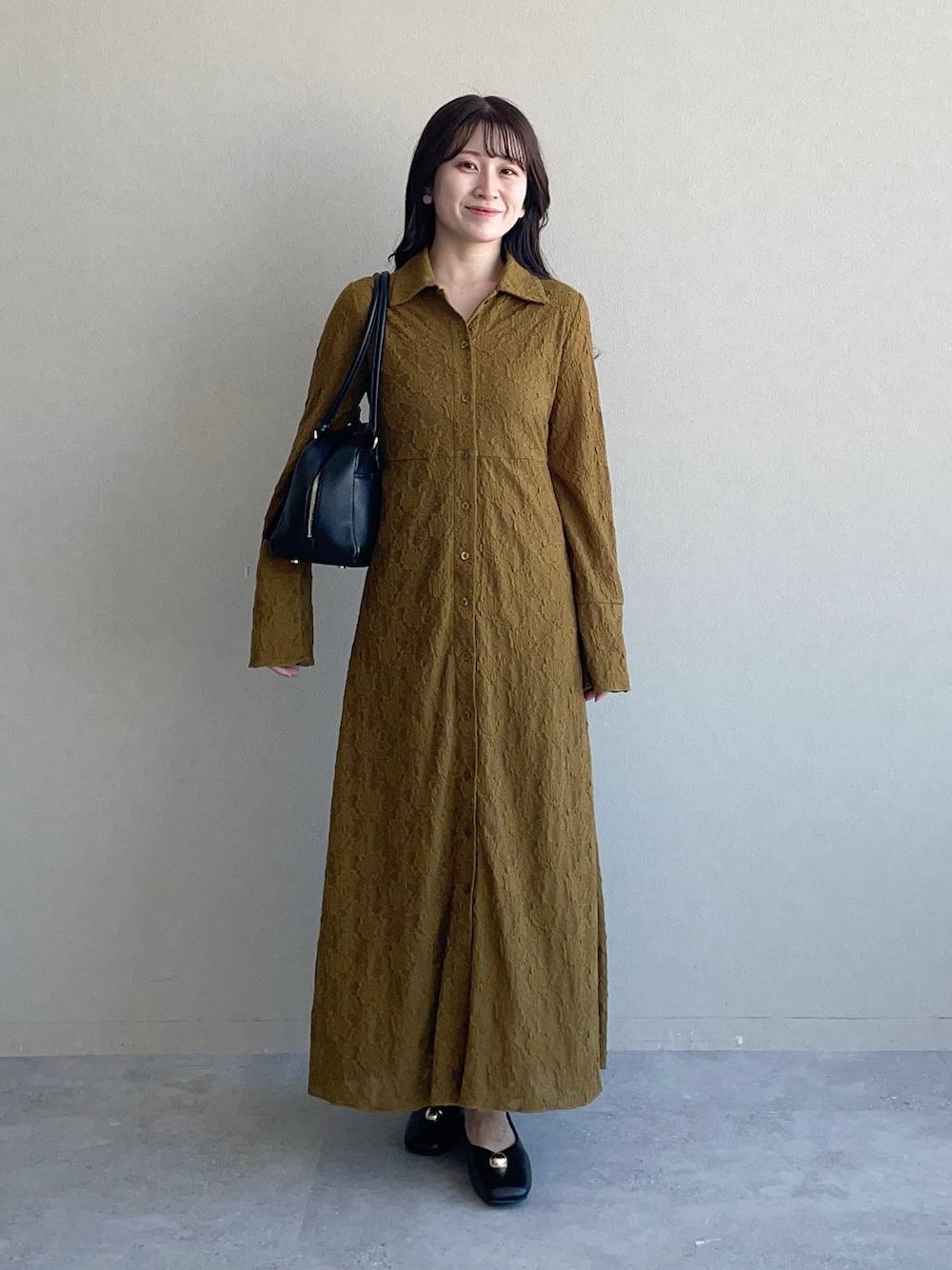 ブラック系のハンドバッグ、イエロー系のワンピース、ブラック系のバレエシューズを着用したレディースの秋コーディネートの1枚目の写真