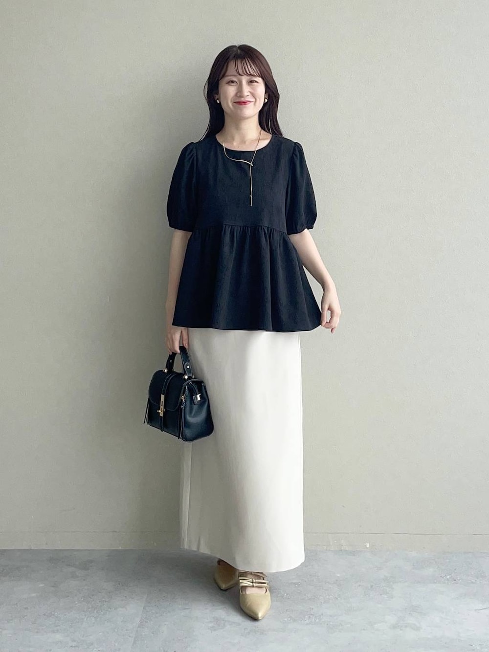 ゴールド系のパンプス、ブラック系のショルダーバッグ、ブラック系のシャツ/ブラウスを着用したレディースの夏コーディネートの1枚目の写真