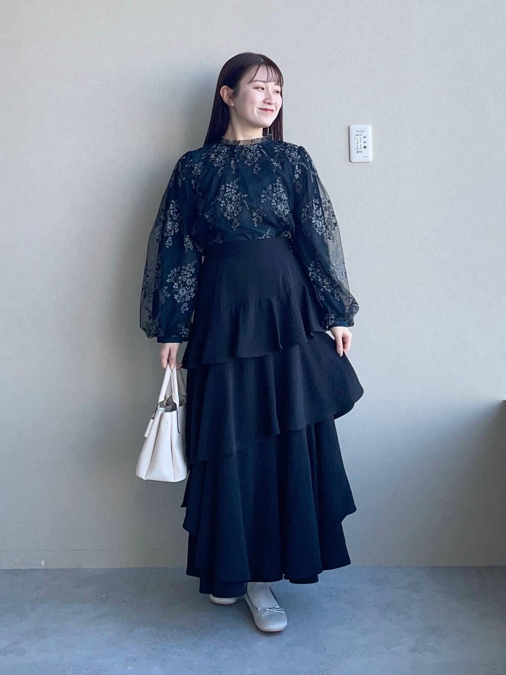 ブラック系のシャツ/ブラウス、ブラック系のスカート、ホワイト系のショルダーバッグを着用したレディースの冬コーディネートの1枚目の写真