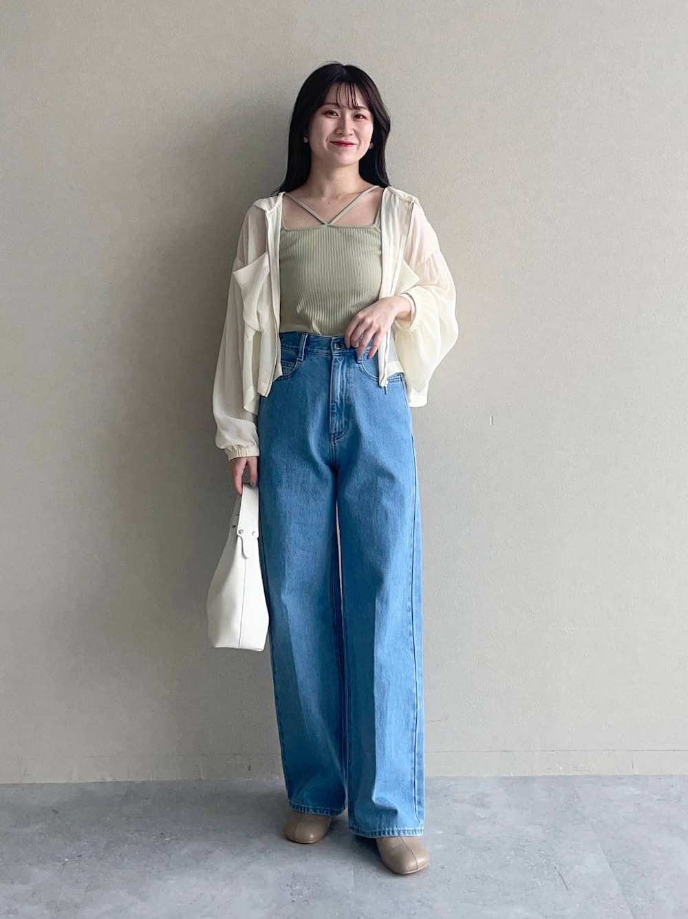 ホワイト系のパーカー、ブルー系のデニムパンツ、ブラウン系のパンプスを着用したレディースの夏コーディネートの1枚目の写真